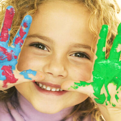 Smiling Girl with Hands Covered in Paint --- Image by  Royalty-Free/Corbis