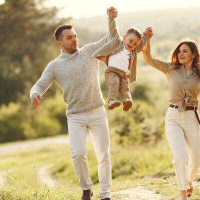 Familie mit kleinen Kind geht in der Natur spazieren.