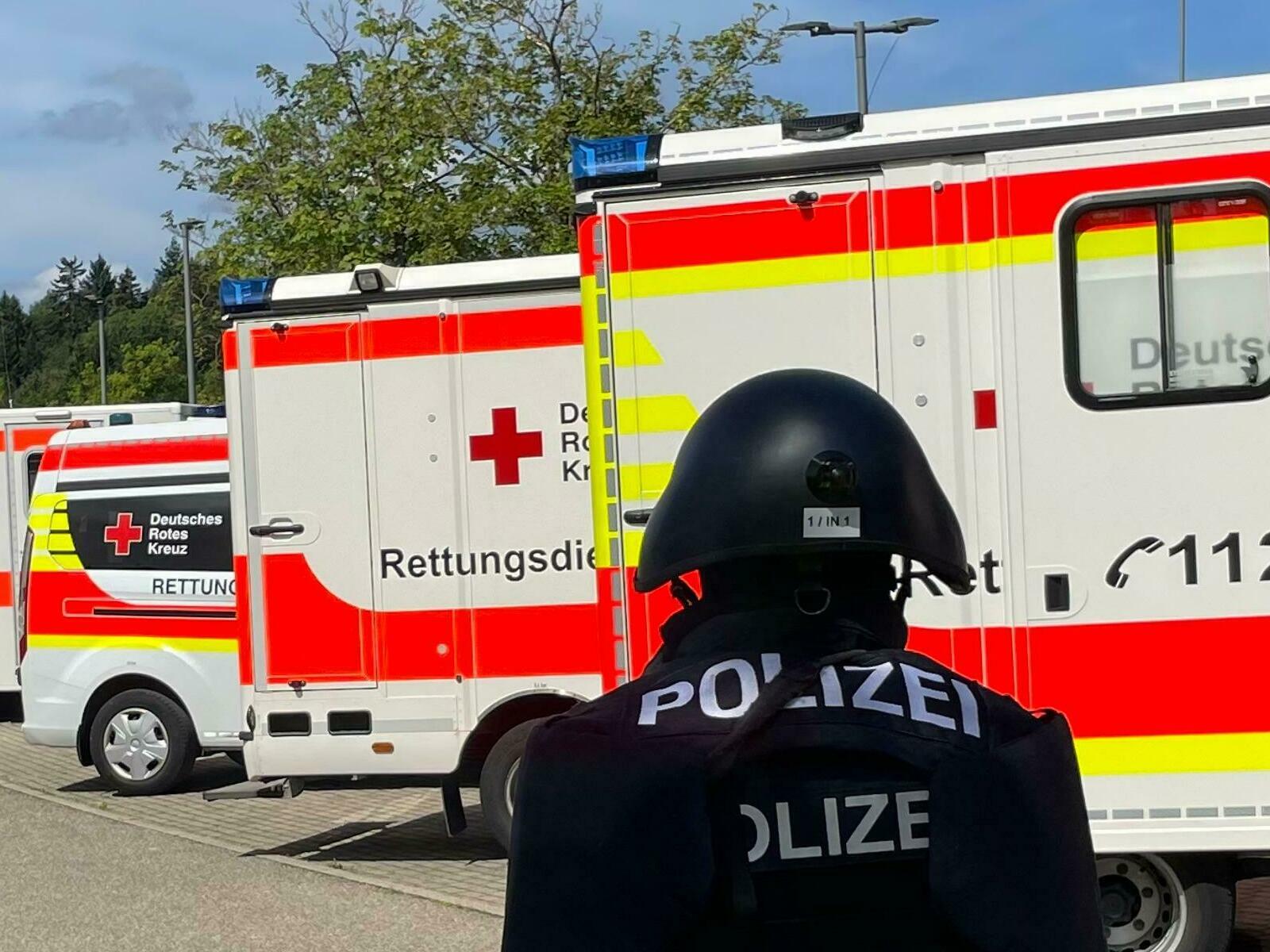 Polizist mit DRK-Fahrzeugen