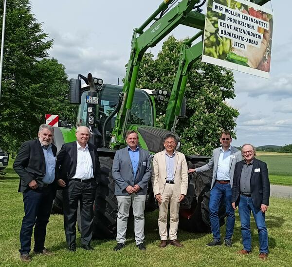 Die Referenten vor einem Schlepper der ZG Donaueschingen mit Protestplakat (von links): Bernhard Bokart, Dr. Detlef Herbner, Dr. Matthias Wider, Dr. Hiroto Oka, Kreisarchivar Clemens Joos und Dr. Casimir Bumiller.